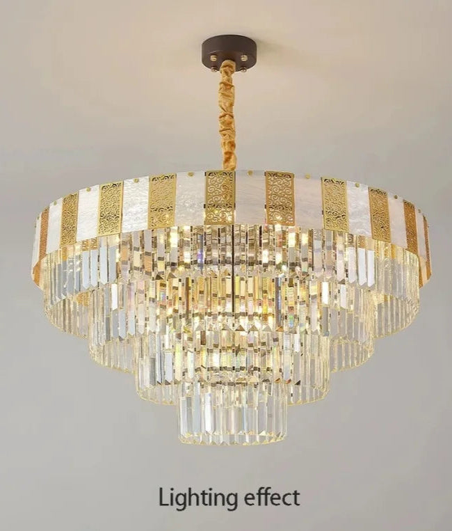 Tiered faceted crystal chandelier with polished chrome accents and a central light source, suspended from a ceiling.