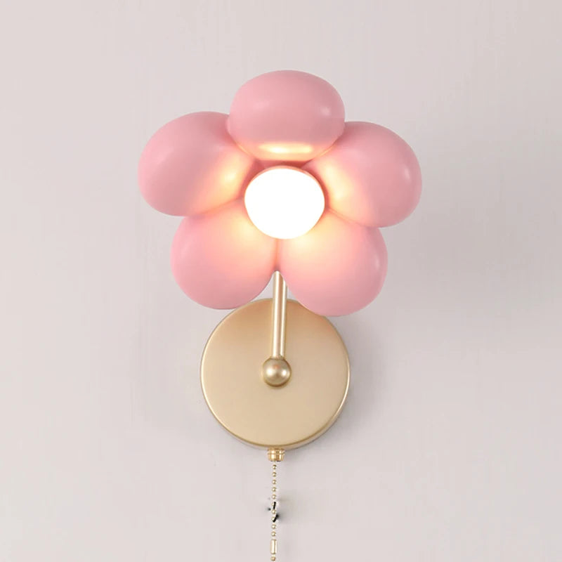 Pink flower-shaped wall light fixture on a plain background