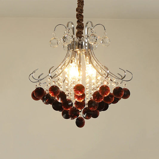 Close-up view of a crystal chandelier with wine red accents, showcasing its polished finish and intricate design.