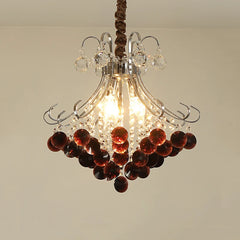Close-up view of a crystal chandelier with wine red accents, showcasing its polished finish and intricate design.
