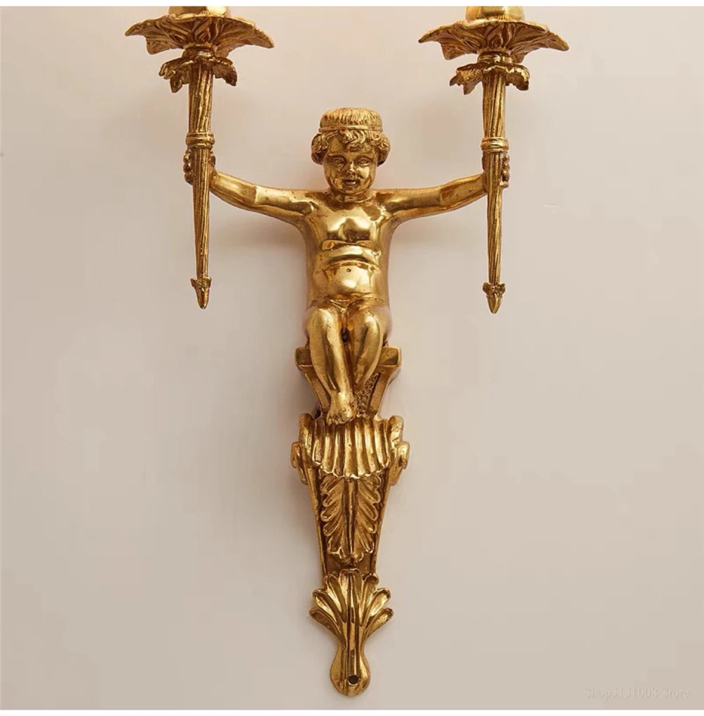 Gold wall sconce with cherub design on a beige background