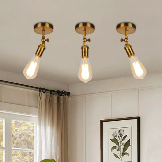 Three gold industrial-style ceiling lights with adjustable folding arms and exposed Edison-style bulbs, installed on a white ceiling.