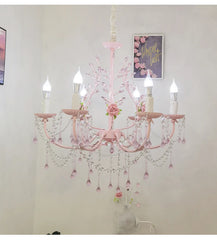 A wider shot of the pink floral crystal chandelier installed in a room, showcasing its scale and design.