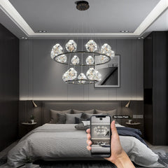 Two-tiered chandelier with crystal orb accents and gold frame in a bedroom setting.