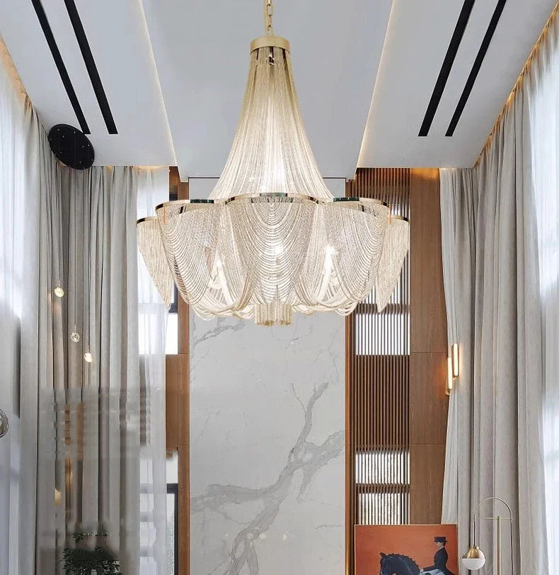 Luxurious chandelier hanging in a modern interior setting with marble walls and wooden panels.