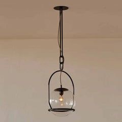 Close-up of the gold metal frame and clear glass globe of a pendant light, showing the E27 socket inside.