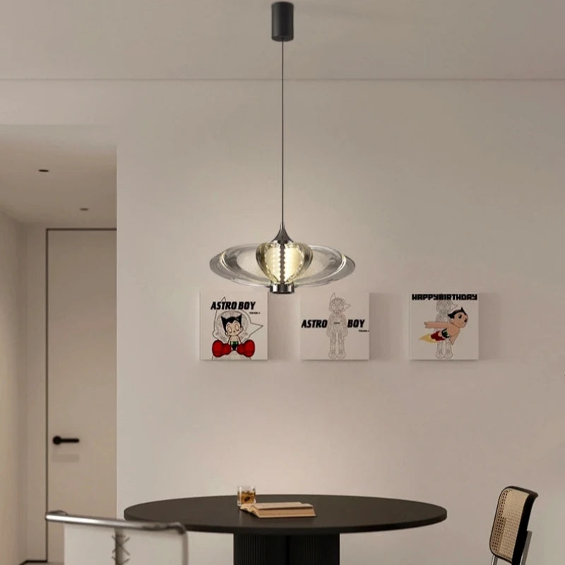 Modern pendant light hanging above a round table with 'Astro Boy' posters on the wall.