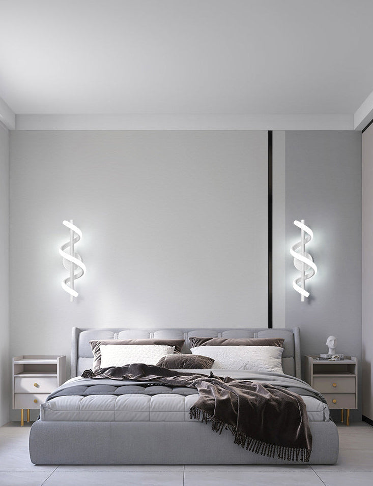Modern bedroom with a gray bed and decorative pillows, featuring wall lights.