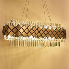 Close-up of a gold and crystal tiered chandelier showcasing the geometric diamond pattern and faceted crystals.