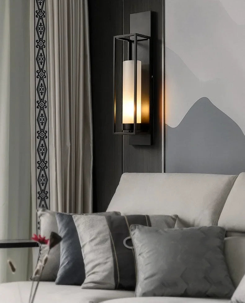 Modern wall sconce above a sofa with decorative pillows