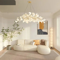 Close-up of a white ceramic ginkgo leaf shade on a gold branch of the pendant light