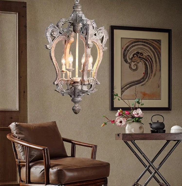 Decorative chandelier hanging above a brown armchair in a room with a table and artwork.