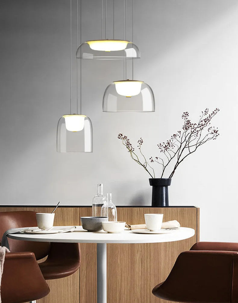 Modern dining area with round table, chairs, and pendant lights.