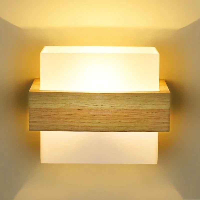 Front view of a wall-mounted light fixture with a central wooden element sandwiched between two frosted glass panels, casting a soft glow.