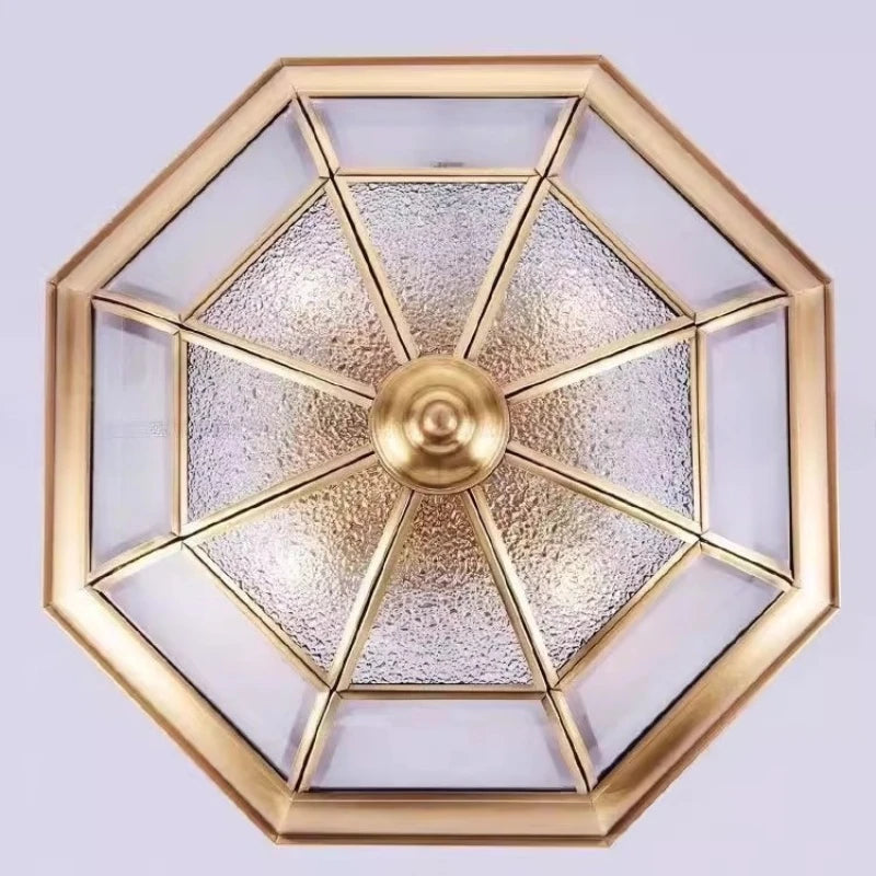 Decorative ceiling light fixture with gold frame and glass panels on a white background