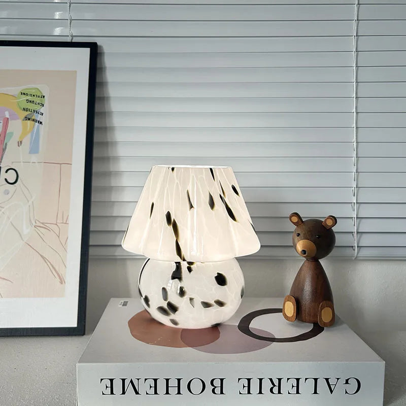 Table lamp with spotted design and wooden bear figurine on a surface with 'Galerie Boheme' branding.