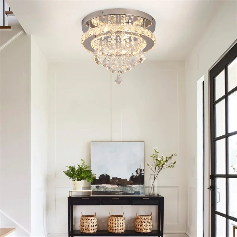 Chandelier hanging in a room with a console table and decor items.