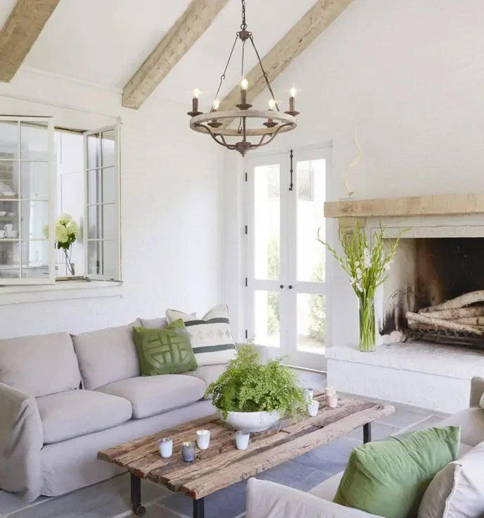 Cozy living room with white walls, wooden beams, and a fireplace.