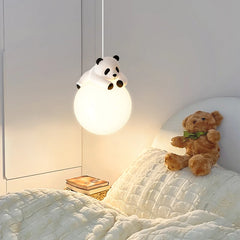 White globe pendant light with a white panda figurine resting on top, hanging in a child's bedroom.
