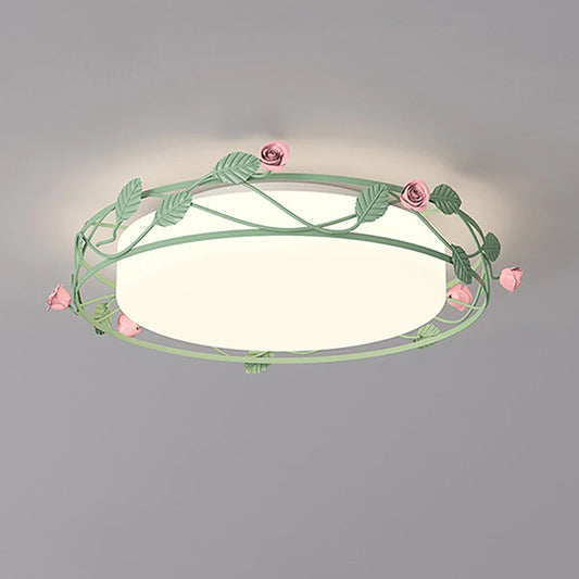 A green metal flush mount ceiling light decorated with pink roses and green leaves, illuminating a room.