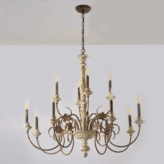 Close-up view of the distressed wood finish and floral detailing on a candle chandelier