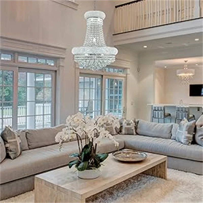 Living room with a large crystal chandelier, sectional sofa, and coffee table.