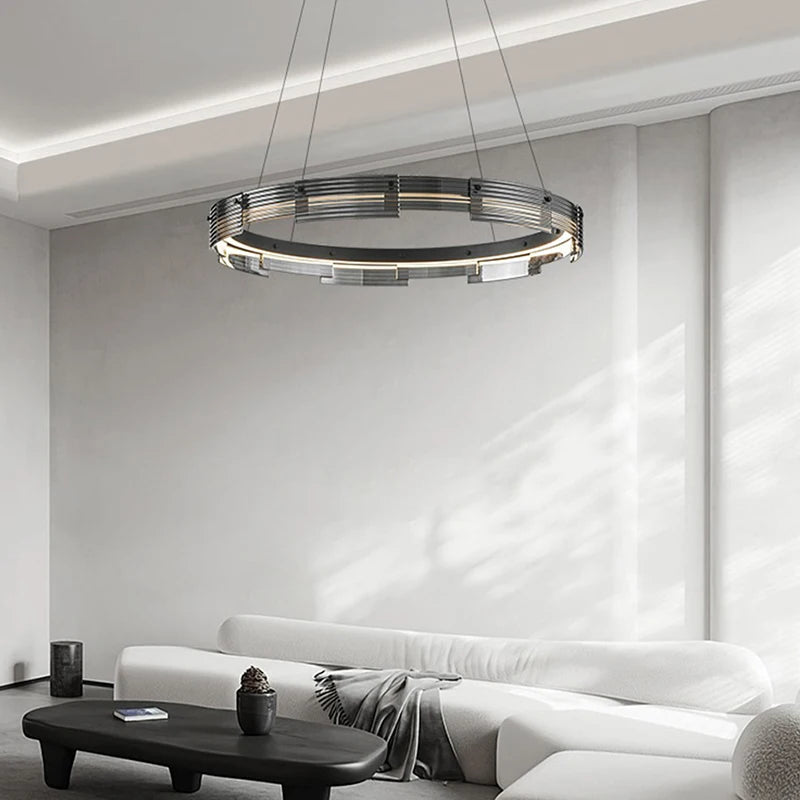 Modern chandelier hanging in a living room with a white sofa and coffee table.