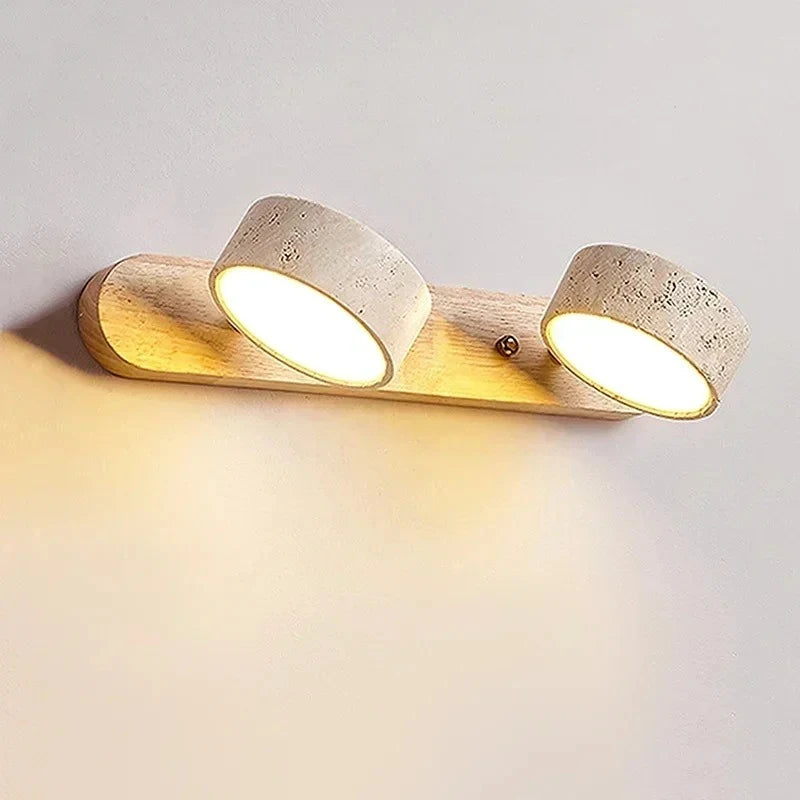 Detail view of the wall sconce showing the texture of the stone shades and the warm glow of the integrated LED lights.