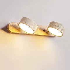 Detail view of the wall sconce showing the texture of the stone shades and the warm glow of the integrated LED lights.