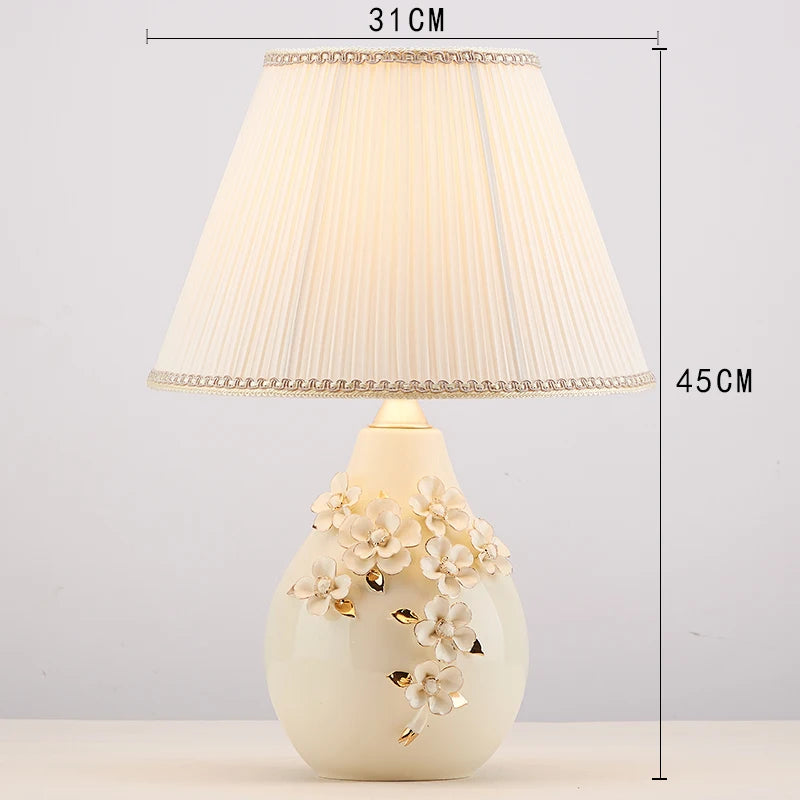 Decorative table lamp with floral design on a white background