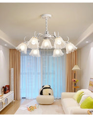 White floral-shaped pendant light with frosted glass shades installed in a bright living room setting.