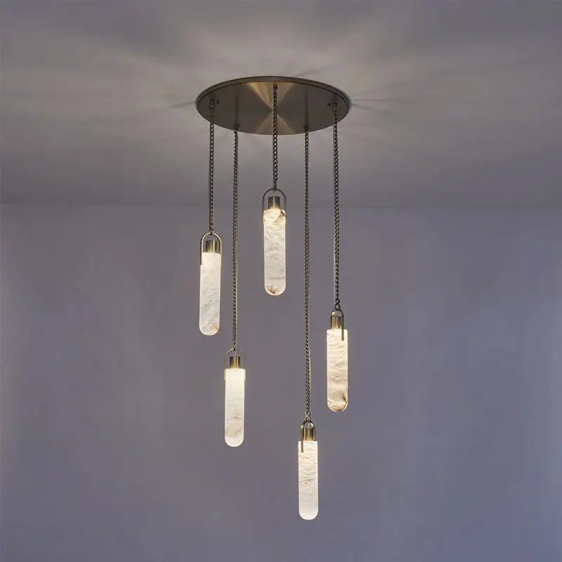 Modern pendant light fixture with hanging glass shades on a gray background