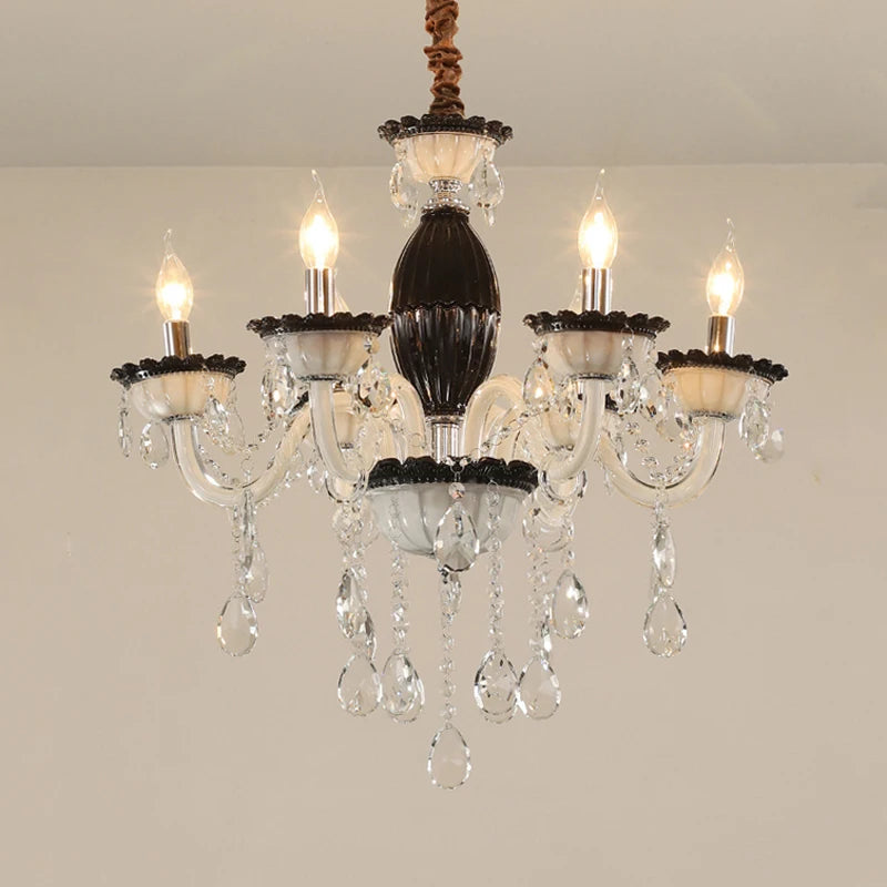 Close-up of a black and crystal candelabra chandelier with five illuminated candle-style bulbs and cascading teardrop crystals.