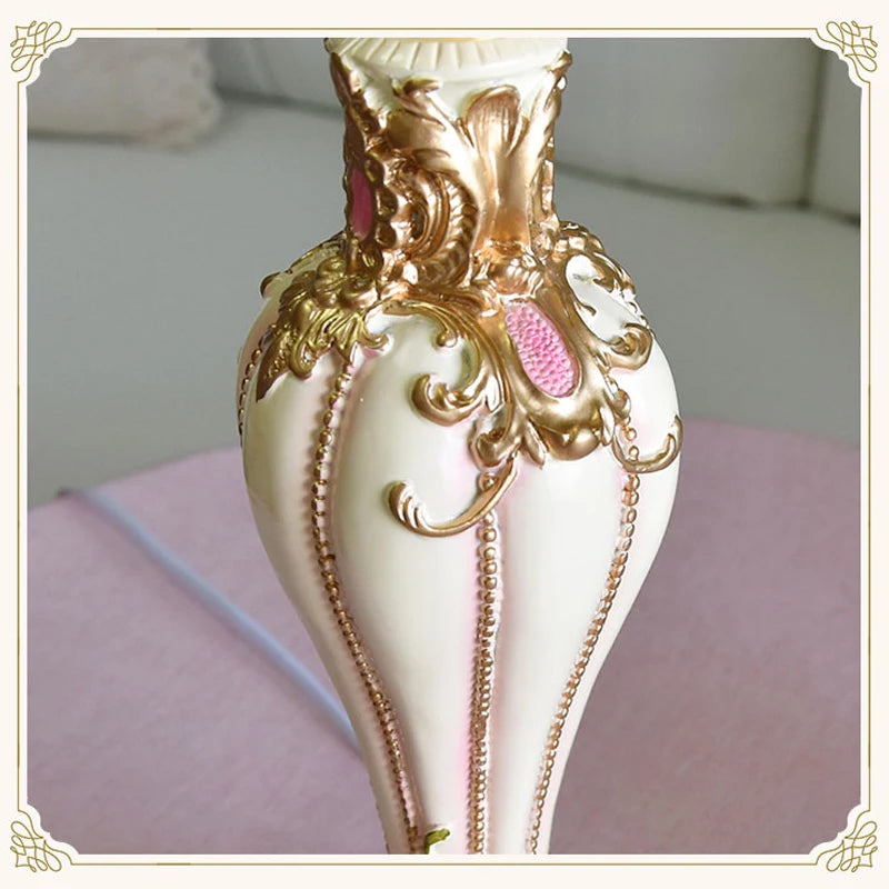 Decorative vase with gold accents on a pink surface