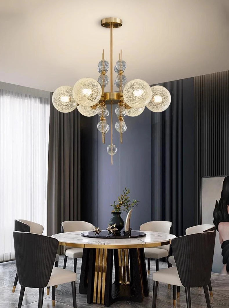 Modern dining room with a chandelier, round table, and chairs.