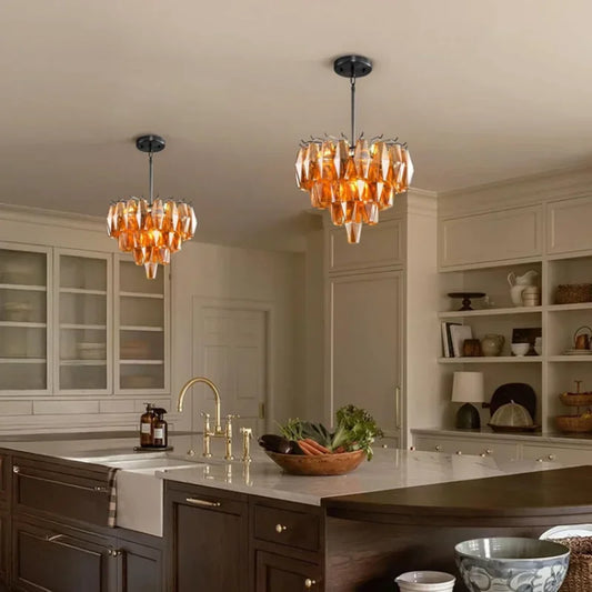 Amber faceted crystal chandelier with a tiered design hanging in a modern kitchen.