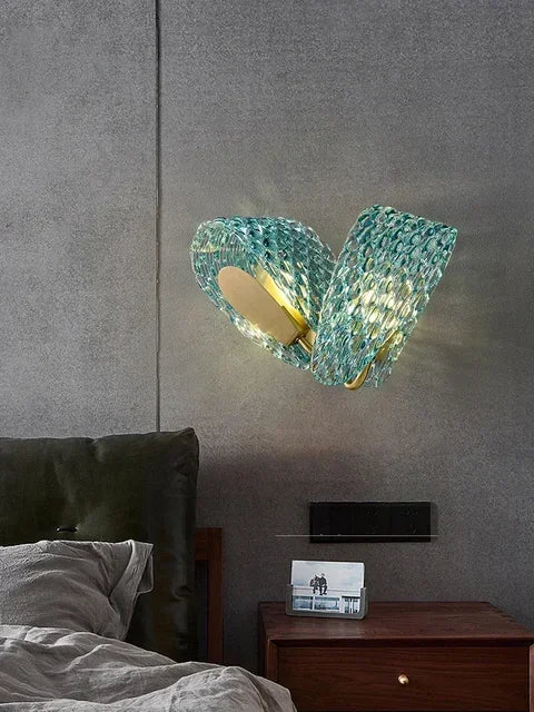 Modern wall-mounted light fixture with textured glass design in a bedroom setting.