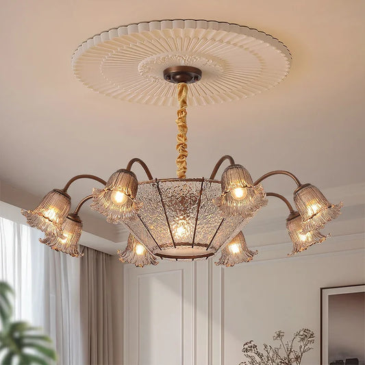 Close-up of the bronze floral glass shade chandelier with light on.