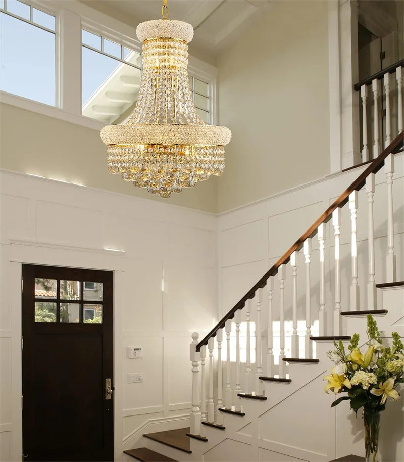 Chandelier hanging in a staircase hallway with a vase of flowers on a step.