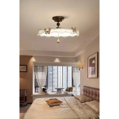 View of the bronze butterfly drum semi-flush ceiling light from a different angle in a bedroom setting.