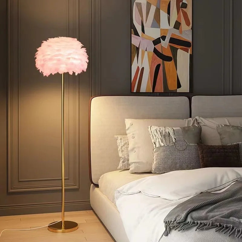 Pink feathered floor lamp in a bedroom setting with a bed and abstract painting.