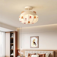 View of a white ceiling light with teddy bear decals, part of a children's bedroom decor featuring a bed and other wall art.