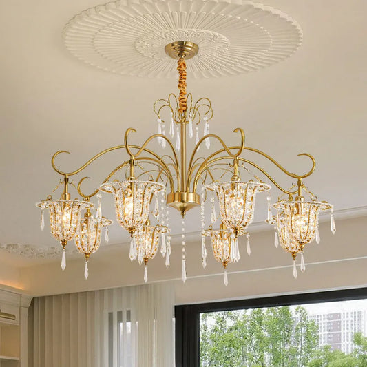 Close-up of the gold crystal chandelier showing the intricate arms, crystal droplets, and bell-shaped light shades.