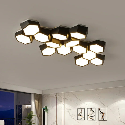 A modern black geometric cluster ceiling light with hexagonal panels emitting a soft white light, mounted on a white ceiling in a contemporary living room.