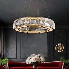 Circular chrome pendant light with clear crystals, suspended from the ceiling in a dimly lit room.