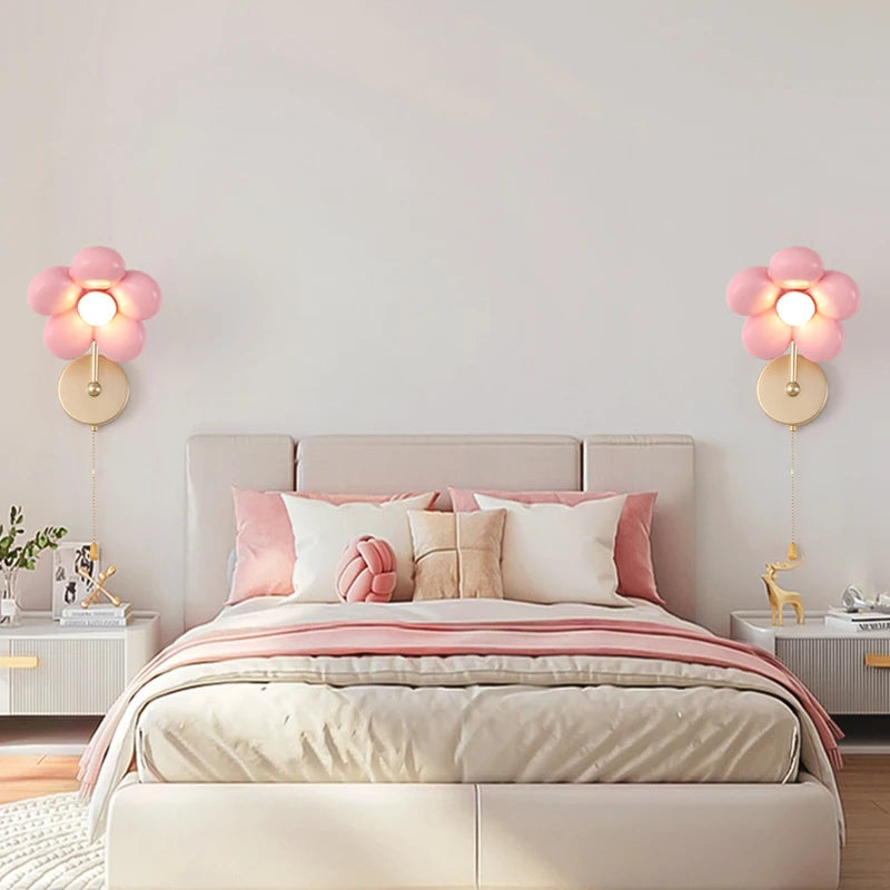 Bedroom with pink wall lights, bed, and decorative items.