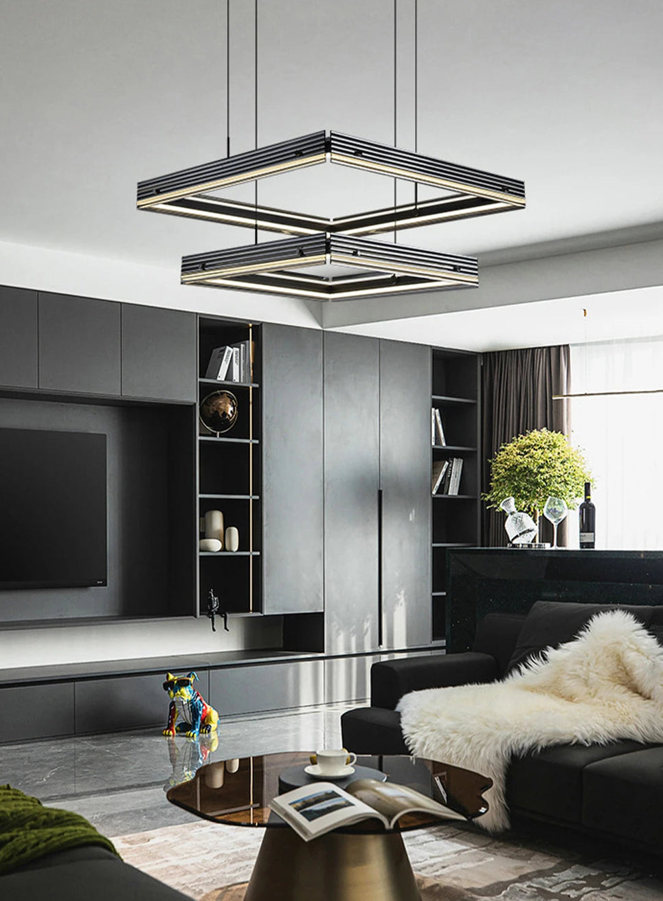 Modern living room with a stylish chandelier, black sofa, and decorative items.
