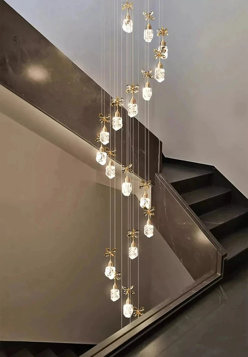 Modern chandelier hanging above a staircase with a neutral background