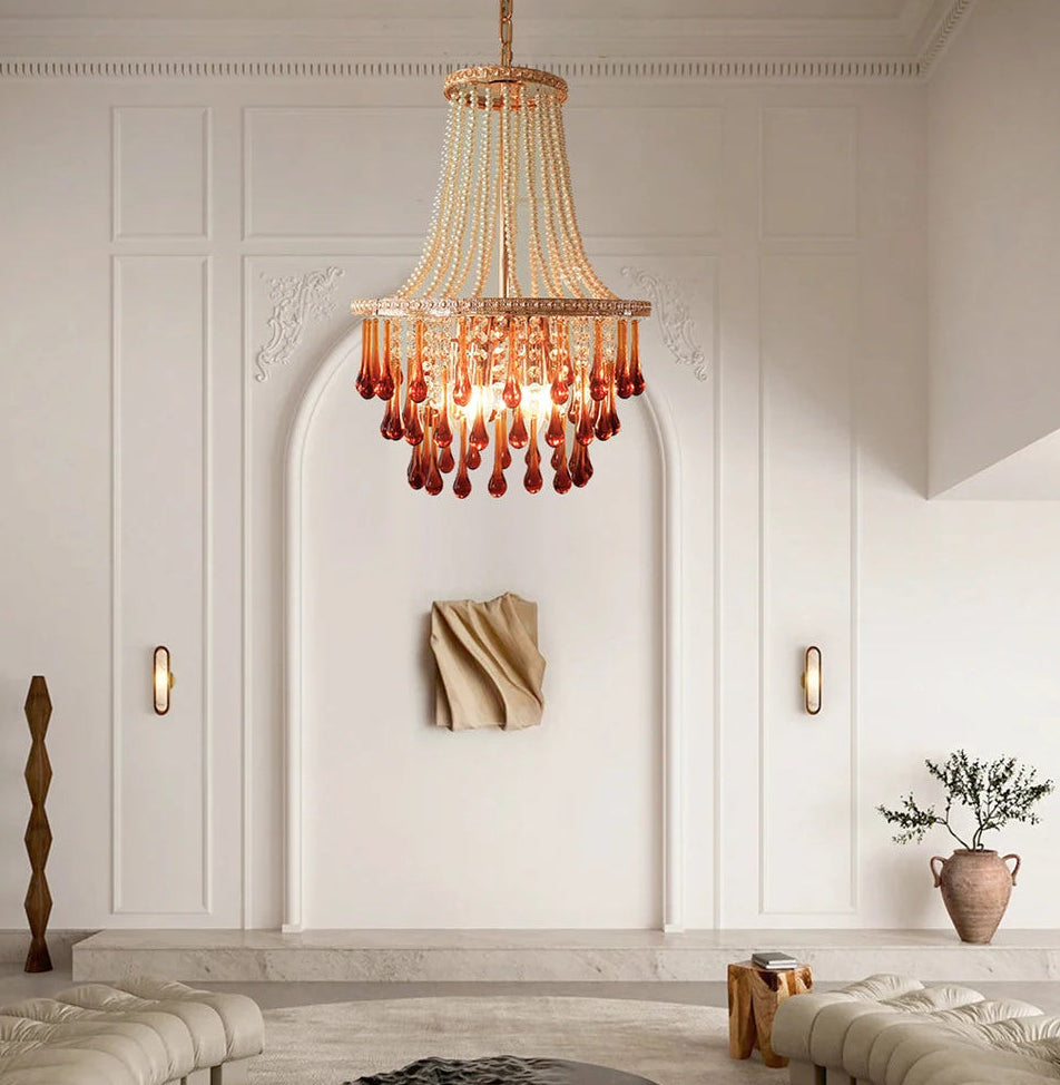 Modern living room with a chandelier, round ottomans, and a textured wall.