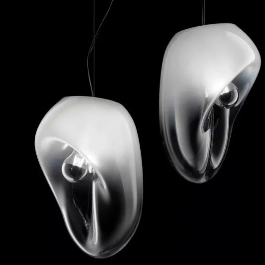 Two smoke gray glass organic shape pendant lights against a black background.